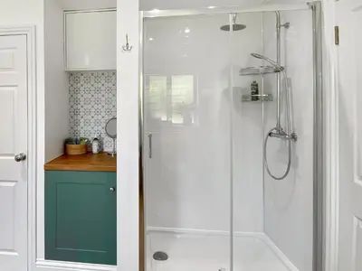 a shower with a glass door in a bathroom at Rose Cottage in Blakemere