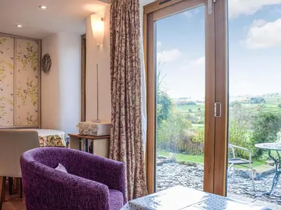 a room with a sliding glass door with a view at Pentre Cwm Bach in Llansilin