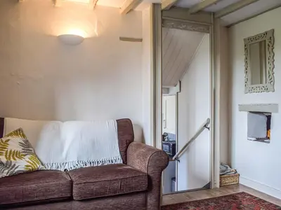 a living room with a couch and a mirror at Pentre Cwm Bach in Llansilin
