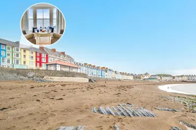 a view of a sandy beach with buildings in the background at 2 Bed in Aberystwyth oc-bow200 in Aberystwyth