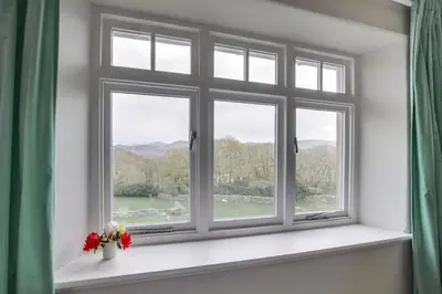 a window with a vase of flowers on a window sill at 4 Bed in Barmouth oc-bow259 in Barmouth