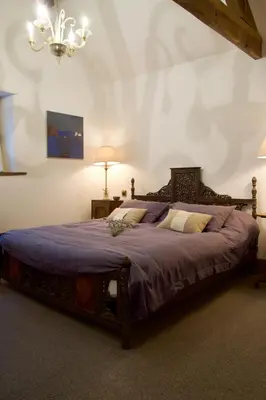 a bedroom with a large bed with a purple blanket at The Pavement Palace in Hay-on-Wye