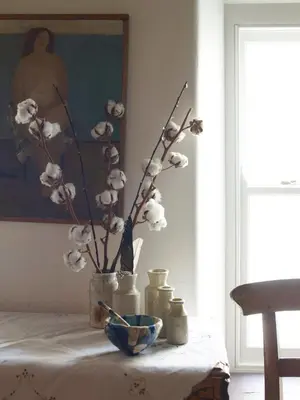 a table with a vase with white flowers on it at The Pavement Palace in Hay-on-Wye