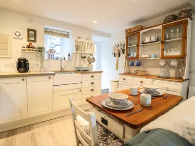 a kitchen with a wooden table in a room at Cartrefle in Bala