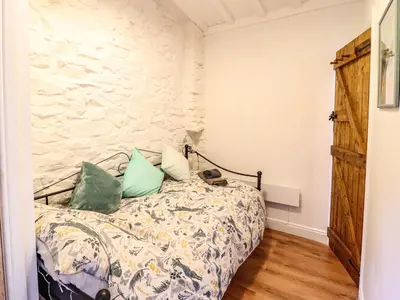a bedroom with a bed and a stone wall at Cartrefle in Bala