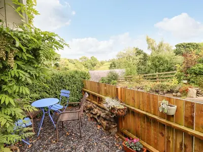 a patio with a table and chairs and a fence at Cartrefle in Bala
