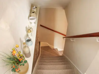 a staircase with a plant and vases on the wall at 55 Corve Street in Ludlow