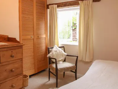 a bedroom with a chair next to a window at 55 Corve Street in Ludlow