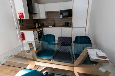 a glass table and chairs in a small kitchen at Ty Belgrave in Aberystwyth