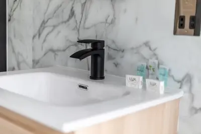 a black faucet on a white sink in a bathroom at Ty Belgrave - Apartment 2 in Aberystwyth