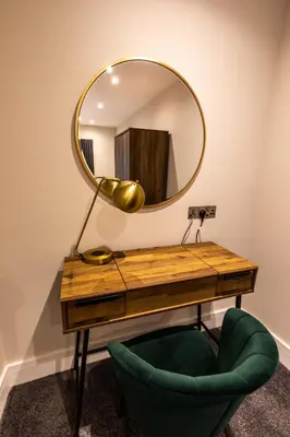 a desk with a mirror and a green chair at Ty Belgrave - Apartment 3 in Aberystwyth