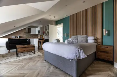 a bedroom with a bed and a living room at Ty Belgrave - Apartment 4 in Aberystwyth