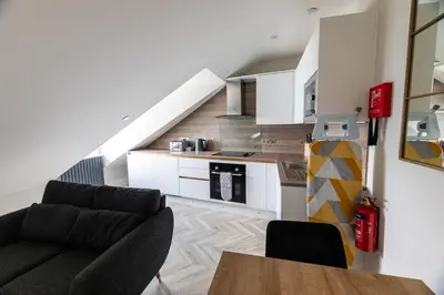 a living room with a couch and a table at Ty Belgrave - Apartment 4 in Aberystwyth
