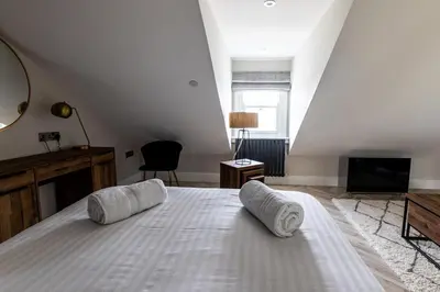 a bedroom with a bed with two pillows on it at Ty Belgrave - Apartment 4 in Aberystwyth
