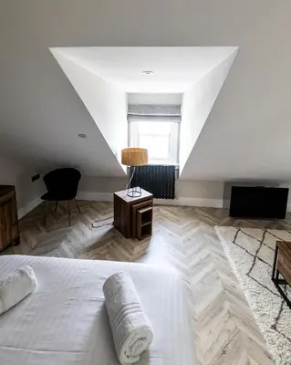 a bedroom with a white bed and a window at Ty Belgrave - Apartment 4 in Aberystwyth