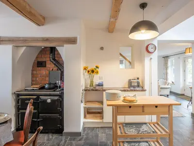 a kitchen with a wooden table and a stove at Top House in Forden
