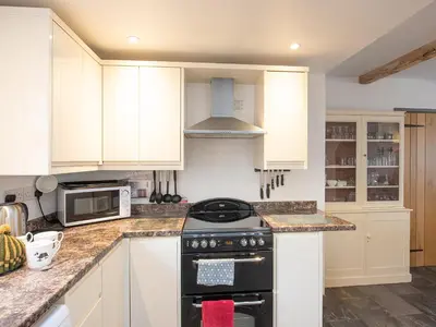 a kitchen with white cabinets and a stove top oven at Top House in Forden