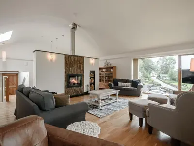 a living room with couches and a fireplace at Hafan Yr Haul in Arthog