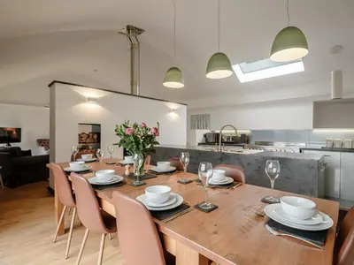 a dining room with a wooden table and chairs at Hafan Yr Haul in Arthog