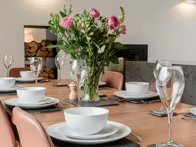 a wooden table with a vase of flowers on it at Hafan Yr Haul in Arthog