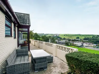 a patio with a table and chairs on a balcony at Frondeg in Aberaeron