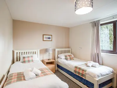 a bedroom with two beds and a window at Frondeg in Aberaeron