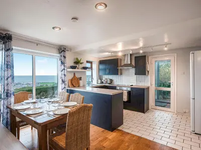 a kitchen with a table with chairs and a dining room at Frondeg in Aberaeron