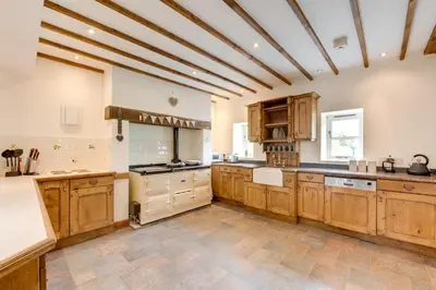 a large kitchen with wooden cabinets and a ceiling at 3 Bed in Tywyn oc-bow248 in Abergynolwyn