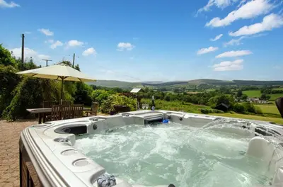 a hot tub in a backyard with an umbrella at 4 Bed in Cray oc-bow288 in Cray