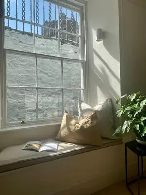 a window seat with pillows sitting in front of a window at Deluxe Apartment in Historic Quarter near Beaches in Aberystwyth