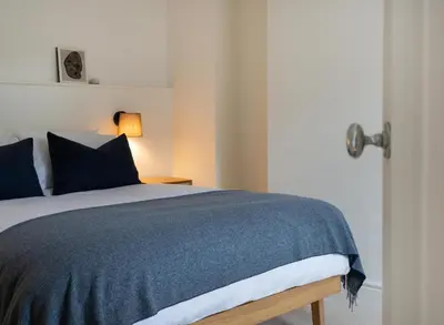 a bedroom with a bed with a blue comforter at Deluxe Apartment in Historic Quarter near Beaches in Aberystwyth
