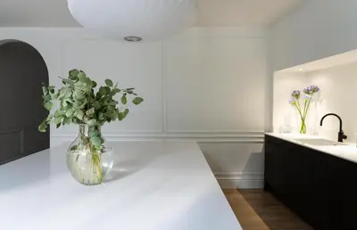 a vase of flowers on a counter in a kitchen at Deluxe Apartment in Historic Quarter near Beaches in Aberystwyth