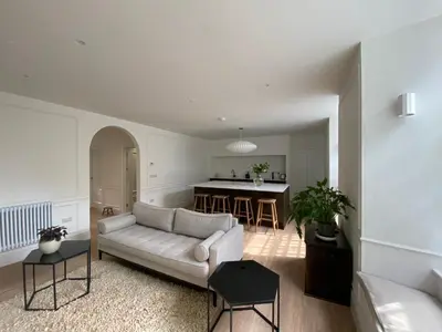 a living room with a couch and a kitchen at Deluxe Apartment in Historic Quarter near Beaches in Aberystwyth