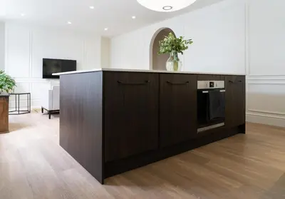 a kitchen with a wooden cabinet and a tv in a room at Deluxe Apartment in Historic Quarter near Beaches in Aberystwyth