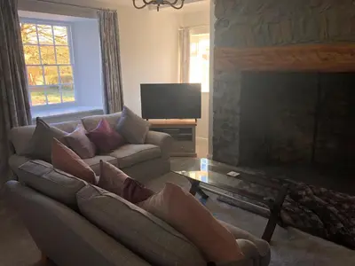 a living room with a couch and a fireplace at Pengarreg Fawr in Aberystwyth