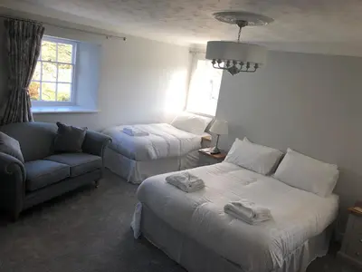 a hotel room with two beds and a couch at Pengarreg Fawr in Aberystwyth