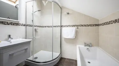 a bathroom with a shower and a sink and a tub at Stunning Barn Conversion with HOT TUB and ALPACAS - Ty Cerrig Barn in Corwen