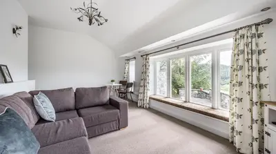 a living room with a couch and a window at Romantic Couples' Getaway - at Ty Cerrig Barn with luxury hot tub in Corwen