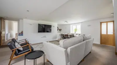 a living room with a couch and a dining room at Romantic Couples' Getaway - at Ty Cerrig Barn with luxury hot tub in Corwen