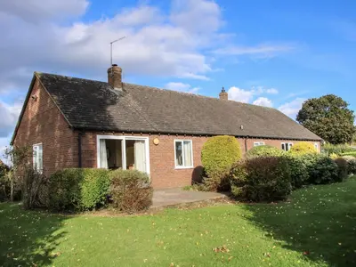 a small brick house with a grass yard at Greenacres in Kimbolton