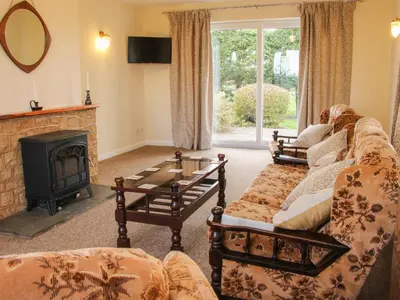 a living room with a couch and a fireplace at Greenacres in Kimbolton