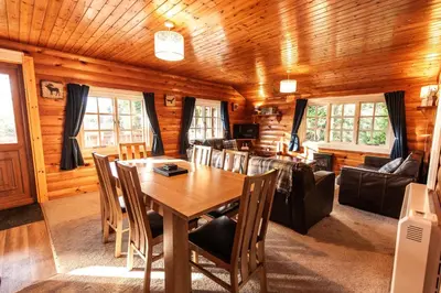 a dining room and living room in a log cabin at 3 Bedroom Log Cabin in Snowdonia nr MTB trails in Tanygrisiau