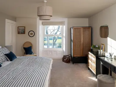 a bedroom with a bed and a window and a dresser at Bennar Fawr in Dyffryn