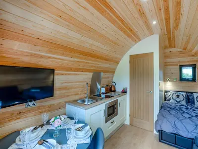 a room with a wooden ceiling with a bed and a kitchen at Elm-Uk36259 in Llanfair Caereinion