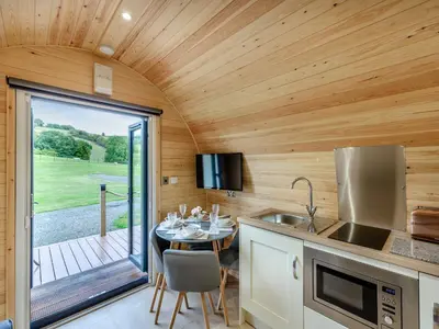 a kitchen and dining room with a table in a tiny house at Elm-Uk36259 in Llanfair Caereinion