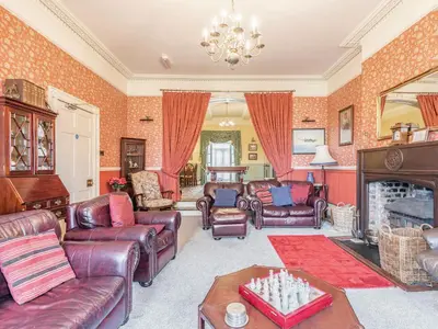 a living room with leather furniture and a fireplace at Edderton Hall Country House in Welshpool
