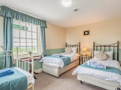 a bedroom with two beds and a window at Edderton Hall Country House in Welshpool