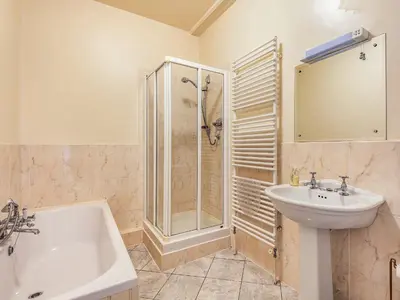 a bathroom with a shower and a sink and a tub at Edderton Hall Country House in Welshpool