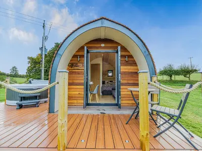 a small wooden cabin with a hammock on a deck at Oak-Uk36258 in Llanfair Caereinion
