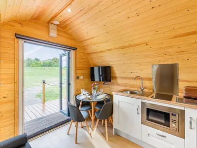 a kitchen with a table with chairs and a patio at Oak-Uk36258 in Llanfair Caereinion